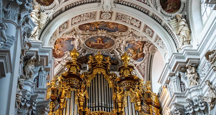 Üppig verzierte goldene barocke Pfeifenorgel unter den freskierten Kuppeln des Passauer Doms.