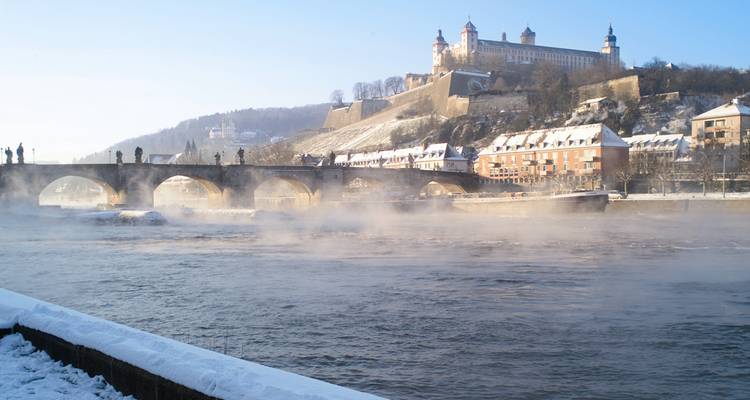 Le brouillard matinal neigeux s'élève de la rivière Main sous le vieux pont et la forteresse de Marienberg à Würzburg