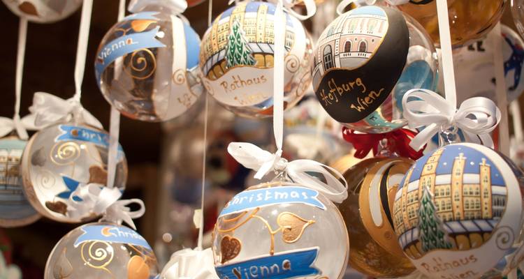 Décorations de Noël peintes à la main représentant des monuments de Vienne suspendues dans un étal de marché festif.