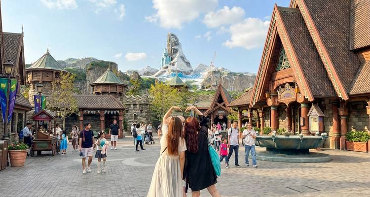 Bezoekers genieten van een sprookjesachtig themagebied van Tokyo DisneySea met alpine kastelen en bergachtergrond.