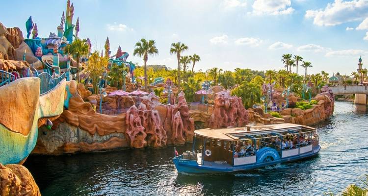 Kleurrijke boottocht passeert grillige rotsformaties en met palmen omzoomde oevers in een DisneySea lagune.