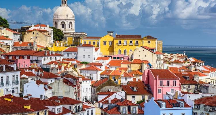 Colorful cascade of terracotta rooftops and pastel facades in Lisbon's Alfama district.