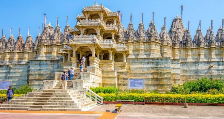 Verzierter Marmor-Ranakpur-Jain-Tempel mit Besuchern, die seine breite Treppe hinaufsteigen.