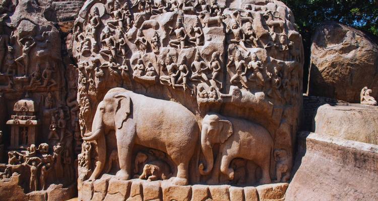 Kunstvolle geschnitzte Flachreliefs mit Elefanten und mythologischen Szenen auf einem riesigen Granitfelsen.