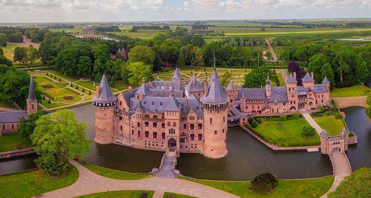 Vista aérea del castillo con torres De Haar rodeado de foso, jardines y campiña holandesa.