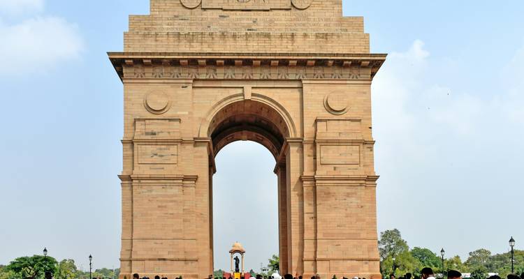 Les foules se rassemblent sous l'imposante India Gate lors d'un après-midi brumeux.