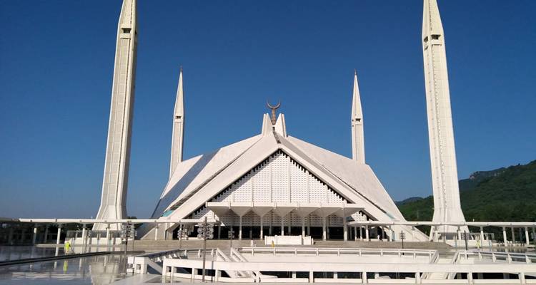 L'architecture moderne blanche saisissante de la Mosquée Faisal sur un ciel bleu profond.