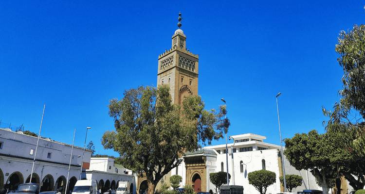 Répétez : scène de minaret avec un ciel bleu clair et des bâtiments blancs environnants