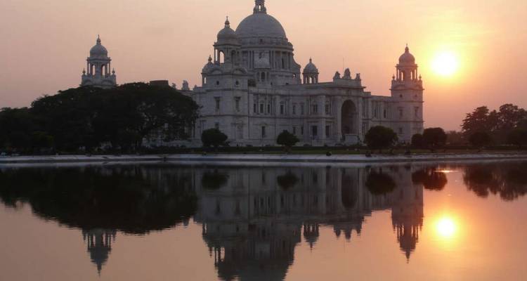 Victoria Memorial spiegelt sich in einem ruhigen See während eines warmen Sonnenuntergangslichts wider.