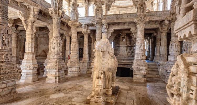 Marmeren olifantenbeeld in de gezuilde hal van de Ranakpur Tempel verlicht door zacht daglicht.