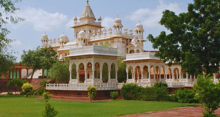 Dichtbij zicht op sierlijke witte cenotafen en goed onderhouden tuinen bij Jaswant Thada.