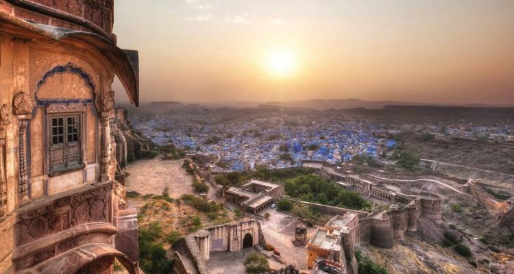 Zonsopgang boven de blauw gekalkte huizen van Jodhpur gezien vanaf de wallen van het Mehrangarh Fort.