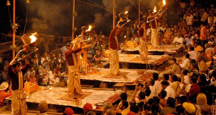 Ceremonia vespertina de Ganga Aarti con sacerdotes agitando lámparas de fuego ante una audiencia abarrotada.