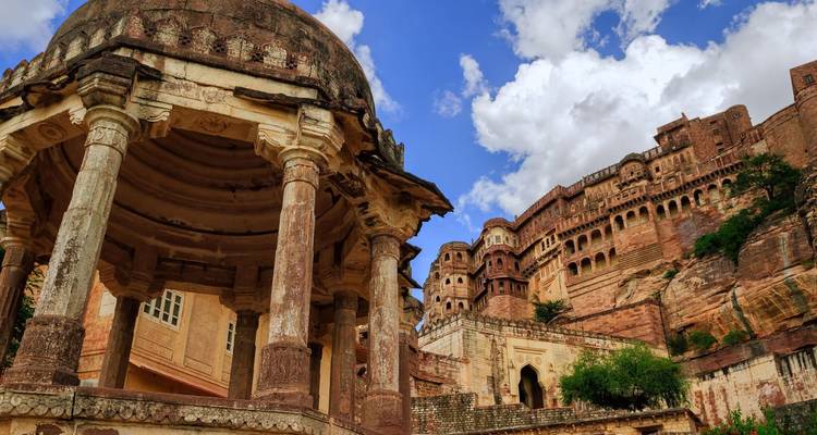 Gros plan du pavillon sculpté et des remparts en grès du fort de Mehrangarh sous un ciel dramatique.