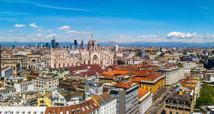 Panorama aérien du Duomo orné de Milan et de l'horizon moderne et historique environnant sous un ciel dégagé.