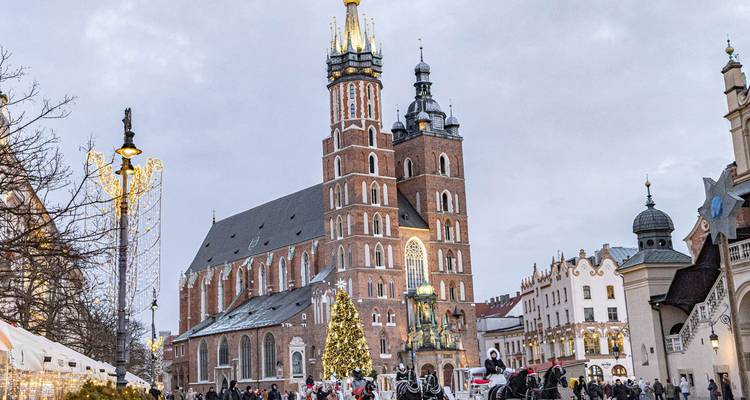 Le marché de Noël festif remplit la place principale de Cracovie devant la basilique Sainte-Marie au crépuscule.