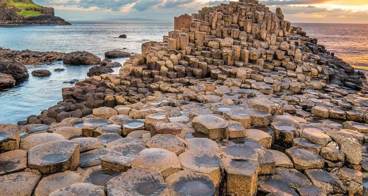 Basalt columns of the Giant’s Causeway meeting the North Atlantic under a dramatic evening sky.