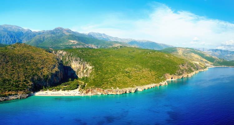 Panorama aérien de la côte escarpée de l'Albanie avec des falaises vertes rencontrant une mer saphir