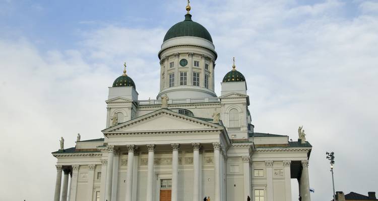 Cathédrale néoclassique d'Helsinki avec ses dômes verts s'élevant contre un ciel pâle.