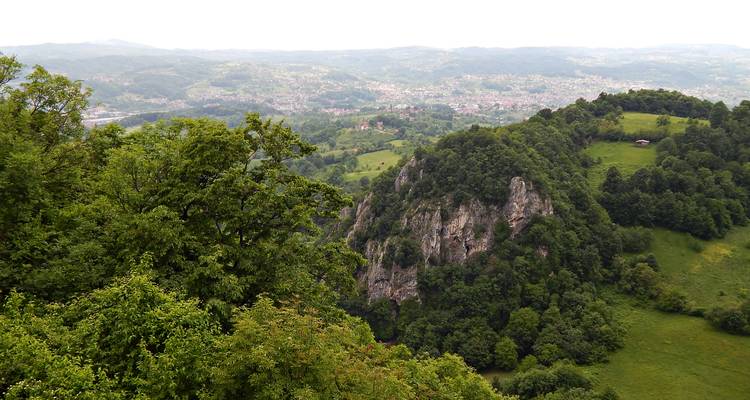 Breed dalzicht met rotsige bergkam en verspreide dorpen gezien vanaf een hoge uitkijkpost.