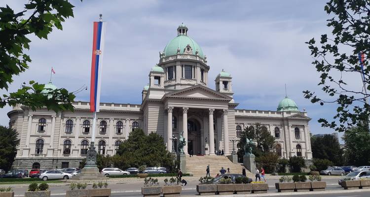 Groots neoklassiek Nationale Assemblee gebouw in Belgrado met Servische vlag en koepeldaken.