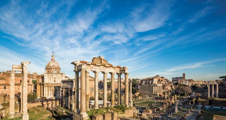 Vista panorámica de columnas antiguas y ruinas de un gran foro bajo cielos azules