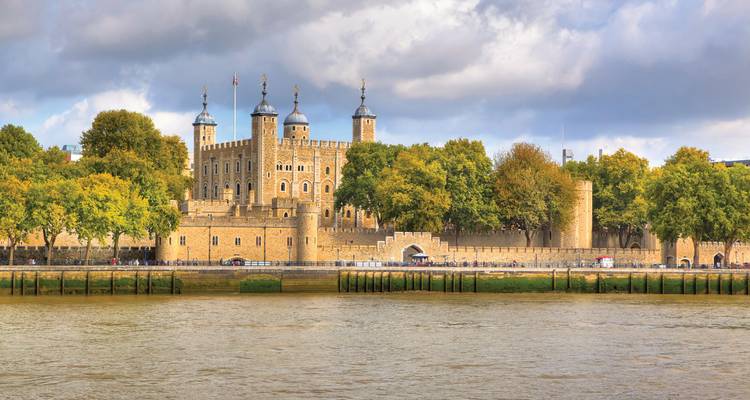 Forteresse historique de la Tour de Londres avec des murs de pierre et des tourelles vue de l'autre côté de la Tamise.