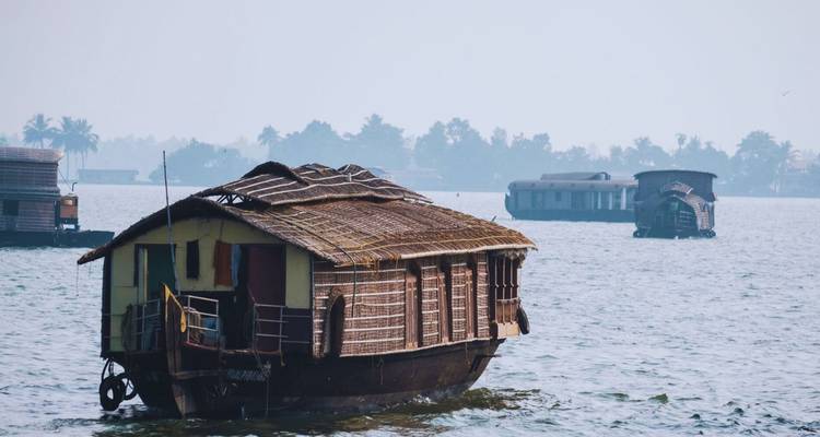 Péniche traditionnelle en bois sur un lagon calme d'eaux dormantes.