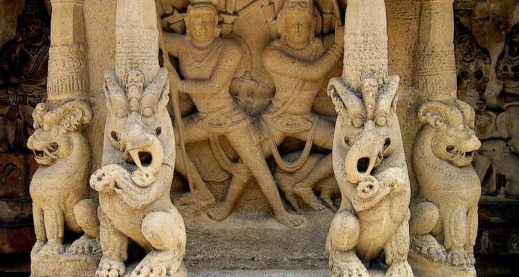 Detaillierte antike Steinskulpturen von Kriegern und mythischen Tieren im Tempelkomplex von Mahabalipuram.