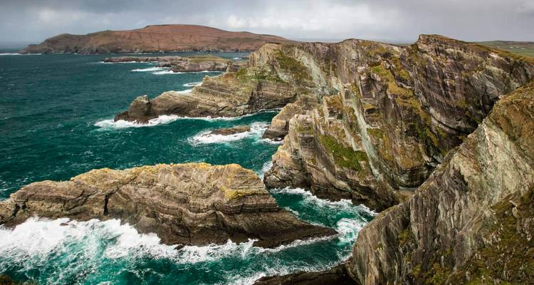 Falaises maritimes escarpées avec des vagues de l'Atlantique qui se brisent et une eau turquoise le long de la Wild Atlantic Way d'Irlande