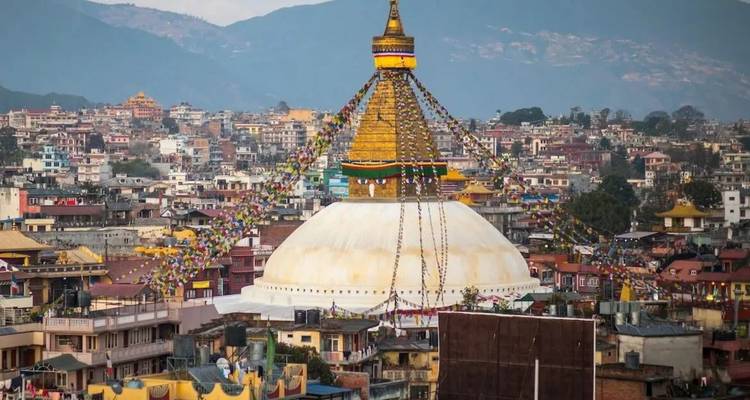 Gouden spits van Boudhanath Stupa die uittorent boven het kleurrijke stadsgezicht van Kathmandu met gebedsvlaggen