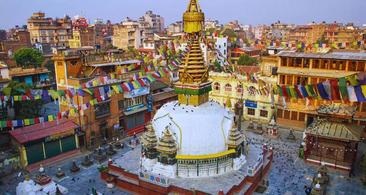 Swayambhunath stupa omgeven door kleurrijke gebedsvlaggen boven de daken van Kathmandu tijdens het gouden uur