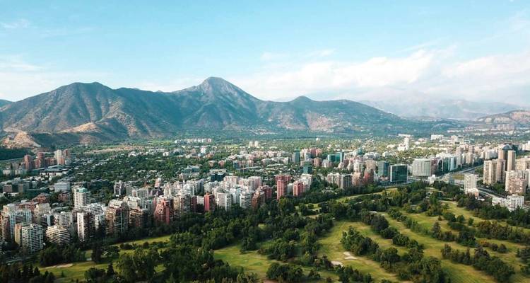 Vue aérienne de l'étalement urbain de Santiago bordé par des parcs verdoyants et les contreforts andins.