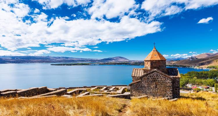 Le monastère de Sevanavank surplombant les vastes eaux bleues du lac Sevan sous un ciel dégagé