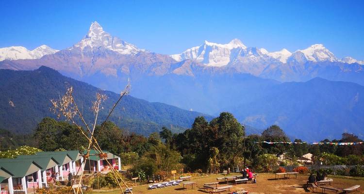 Pavillon et jardin face à la spectaculaire chaîne enneigée du Machhapuchhre et des Annapurna sous un ciel bleu vibrant