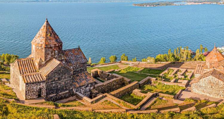 Monasterio histórico de Sevanavank con vista a la vasta extensión azul del lago Sevan.