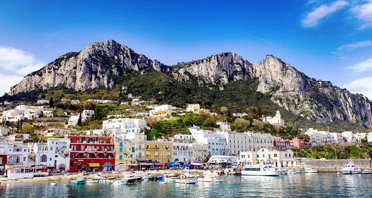 Colorido pueblo costero de Capri situado bajo espectaculares picos de piedra caliza en un día despejado.
