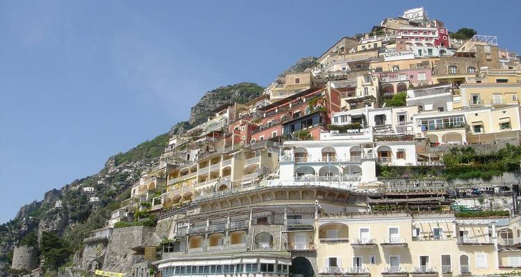 Casas adosadas coloridas apiladas en un acantilado empinado con vista al mar en Positano en la Costa Amalfitana.