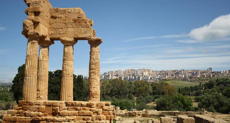 Antiguas columnas de piedra caliza del Templo de Cástor y Pólux en el Valle de los Templos con vista a Agrigento.