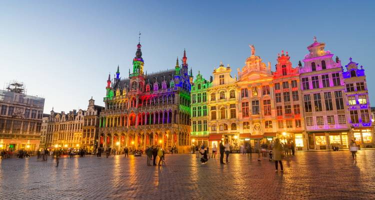 Grote Markt in Brussel verlicht met regenboogkleuren terwijl avondmensenmengte over het geplaveide plein wandelt
