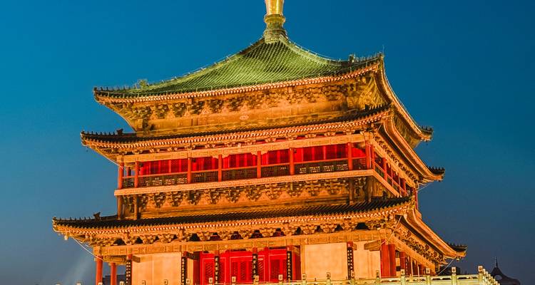 Xi'an’s brightly lit Bell Tower glows against a deep blue night sky.