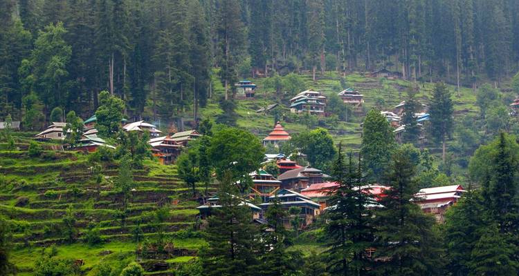 Scattered hillside village nestled among terraced green forest slopes