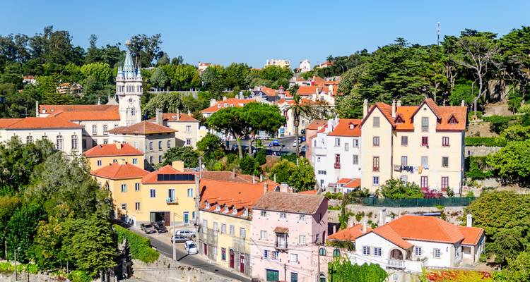 Pintorescos tejados y torre de iglesia del casco antiguo de Sintra entre colinas verdes en un día soleado