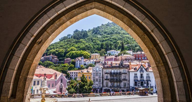 Pueblo en la colina de Sintra enmarcado perfectamente a través de un arco de piedra gótico