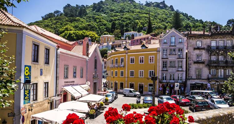 Fachadas coloridas y cafés de la animada plaza de Sintra respaldada por una colina boscosa