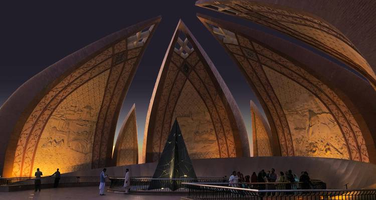 Monument du Pakistan illuminé la nuit avec des visiteurs admirant ses murs en forme de pétales