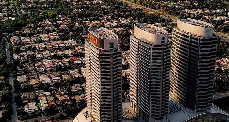 Vue aérienne de trois tours modernes de grande hauteur surplombant le paysage urbain tentaculaire d'Islamabad