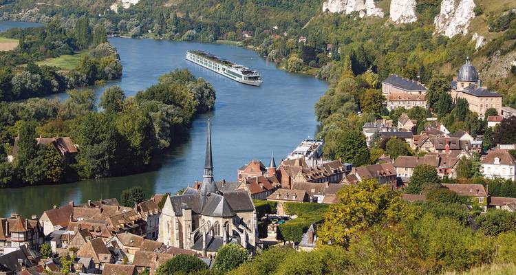 Pittoresk luchtfoto van het dorp Les Andelys langs de Seine met een cruiseschip dat voorbijvaart.