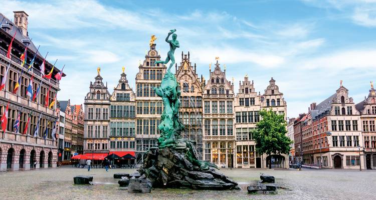 Standbeeld van de Brabofontein te midden van sierlijke gildehuizen op Antwerpen's historische Grote Markt onder een heldere blauwe hemel