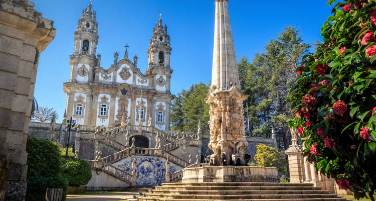 Helle Tagesansicht des Lamego-Heiligtums und Obelisken, eingerahmt von blühenden Kamelien.